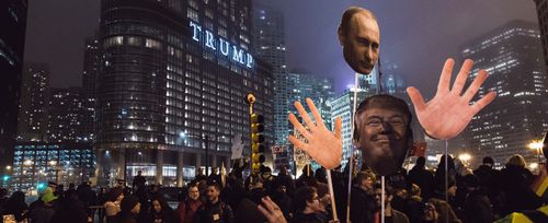 Протестиращ държи чучела с ликовете на Тръмп и Путин пред сградата на Тръмп