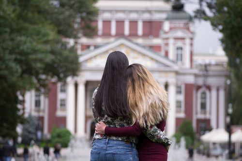 Две момичета в гръб на фона на Народния театър „Иван Вазов“
