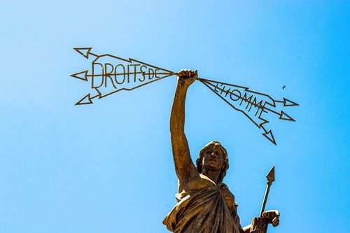 Статуя, държаща стрели с надпис „Човешки права“ на френски език