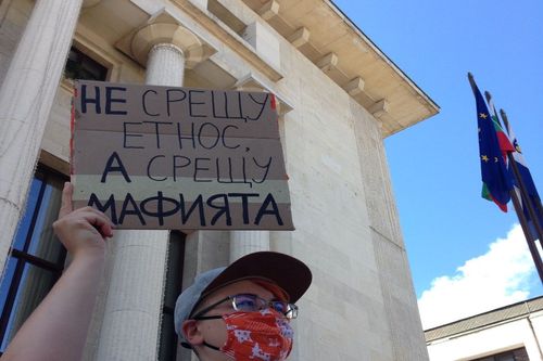 Протестираща държи табела с надпис „Не срещу етнос, а срещу мафията“