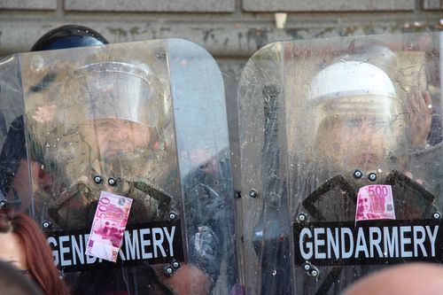 Полицаи от жандармерията държат щитове, омазани с яйца