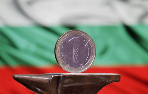 Монета от един лев на фона на българския флаг