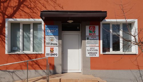 Фасада на пенсионен клуб с табели на ГЕРБ, БСП, „Атака“ и ВМРО