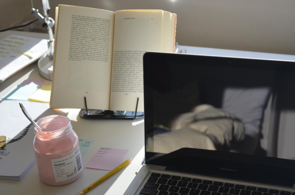 Снимка на бюро с лаптоп, книга, буркан с кисело мляко
