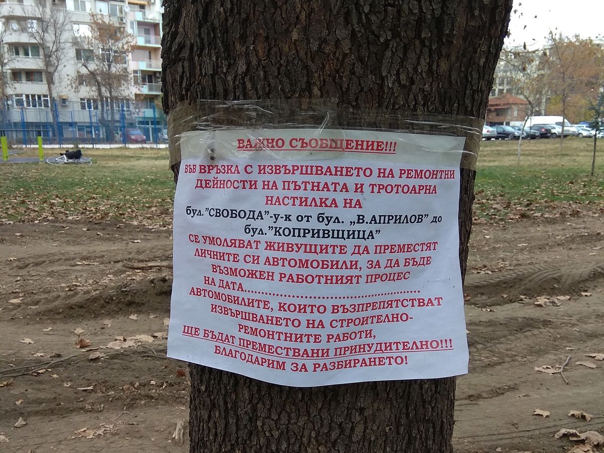Бележка, залепена с тиксо върху дърво, уведомяваща живущите да преместят личните си автомобили поради ремонт на пътя