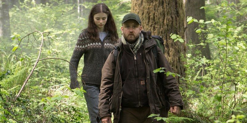 Мъж и младо момиче вървят в гората