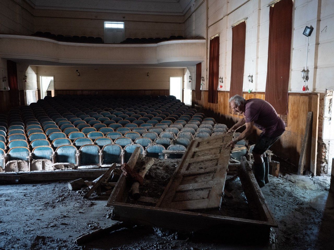 Вълко Шопов, съпруг на секретарката на Народно читалище „Пробуда 1899“ в Каравелово, разчиства сцената, която е пострадала от наводнението © Анастас Търпанов